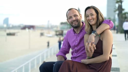 Portrait of Happy Young Couple Hugging Near Beach in City 30s