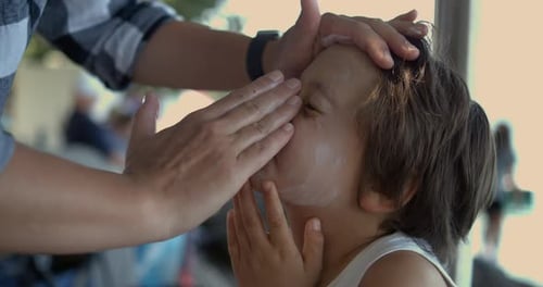 Carefully applying sunscreen to a child's face in slow motion at 800 fps, emphasizing the