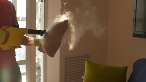 Man Steams Tan Pillow Inside Home During the Day