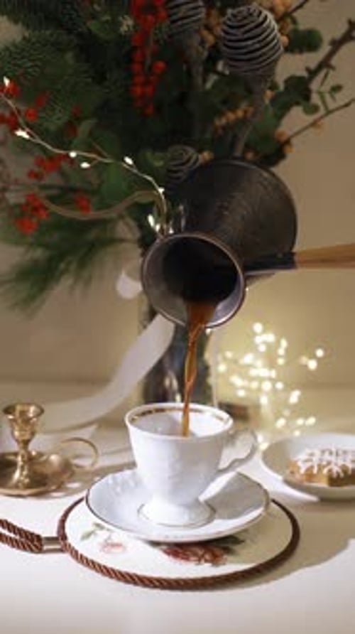 Pour coffee into a cup close-up. Decorated christmas tree on background. Winter holidays concept. Ce