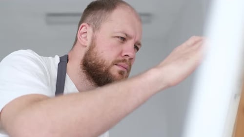 A Man is a Professional Artist Who Paints a Picture in His Studio The Concept of Creating Art