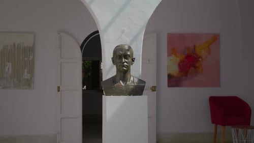 Statue of a George Sebastian on white background with pictures on the walls.