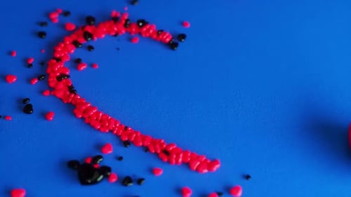 Valentines day hearts slowly being arranged on bright blue background