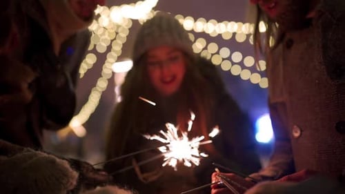 Cheerful Friends Have Fun Partying with Sparklers in Hands at Christmas Market People Jump and Dance
