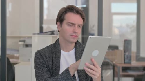 Young Adult Using Digital Tablet in Modern Office