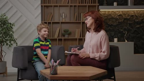 Kid's Therapist Talking to School Boy Sitting at Psychologist Office