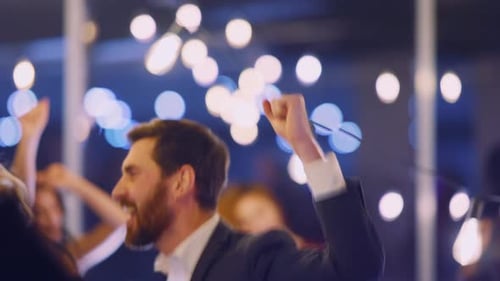 Feliz funcionário caucasiano dançando com colegas multinacionais em festa corporativa festiva