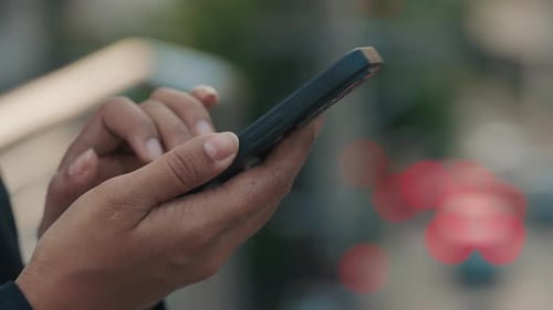 Hands Using Smartphone in Urban Setting Close Up