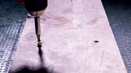 Screwing two bolts in a board. DIY. Craftsman at work.