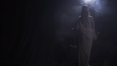 View From the Back of Themis Lifting Up the Scales with Smoke and Low Lighting