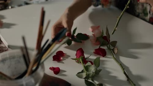 Artistic Floral Arrangement with Red Rose Petals on a White Table
