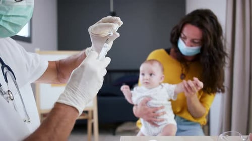 Doctor Prepares Injection for Infant With Mother Present