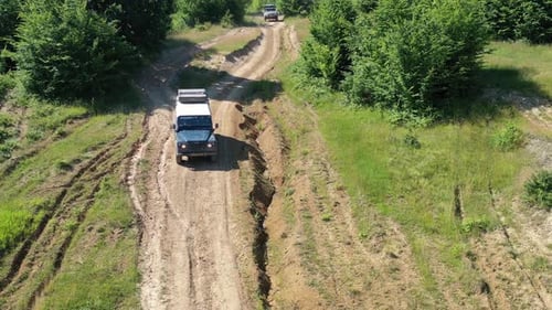 Aerial view of off-road vehicles on dirt path, Romania.