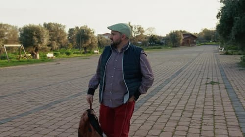 Man Walking in Park with Backpack