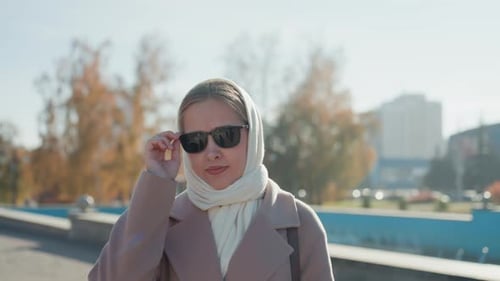 Fashionconscious Woman Exploring City with Serene Surroundings Contemplative Female in Pastel Coat