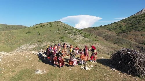 Vue aérienne de femmes en vêtements traditionnels dansant folklorique dans le village entre les montagnes