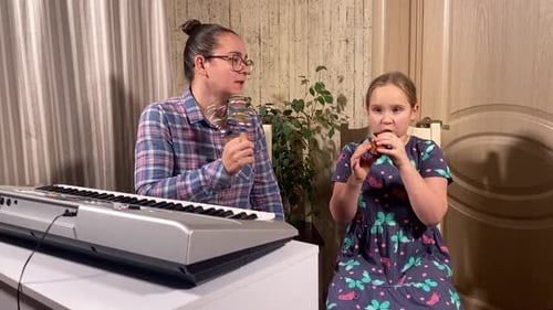 Adult and Child Playing Musical Instruments Indoors
