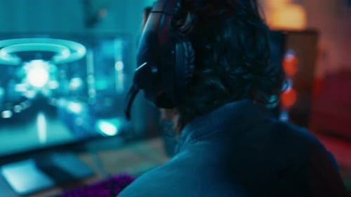 Imagem de close-up de um jogador colocando o fone de ouvido com um microfone e jogando o vídeo de tiro online Ga