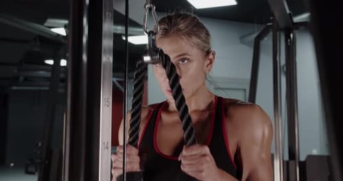 Athletic Woman Bodybuilder Doing Exercises in the Gym