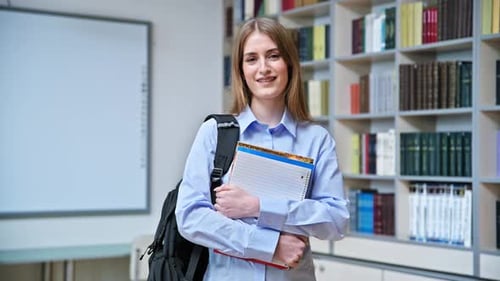 Portrait of Student Teenager Girl Holding Textbooks Inside Classroom Library