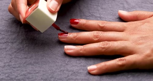 Woman Applying Red Nail Polish for Manicure