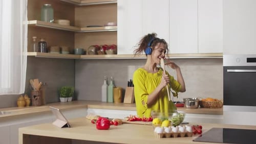 Woman Dances and Sings While Cooking at Home