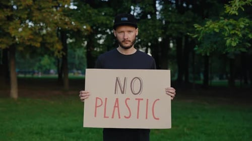 Man Holds No Plastic Sign in Park
