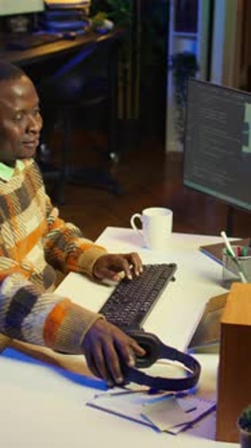 Vertikales Video Afroamerikaner arbeitet am Computer, um Code zu schreiben und zu programmieren