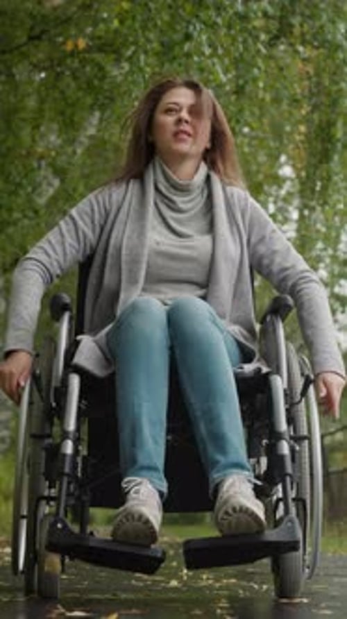 Woman in Wheelchair Walks in Sanatorium Park During Recovery