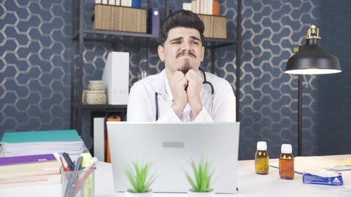 Thoughtful Doctor Working at Desk on Laptop