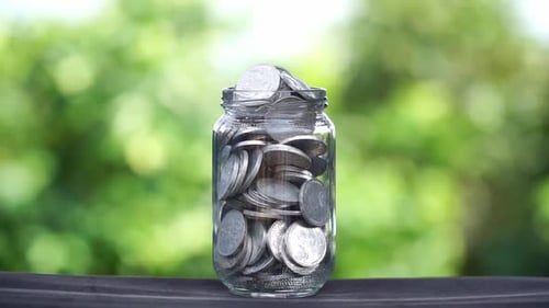 Full jar of money against green natural background, investment concept