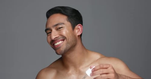 Face, pipette and Asian man with skincare, oil and dermatology on a grey studio background