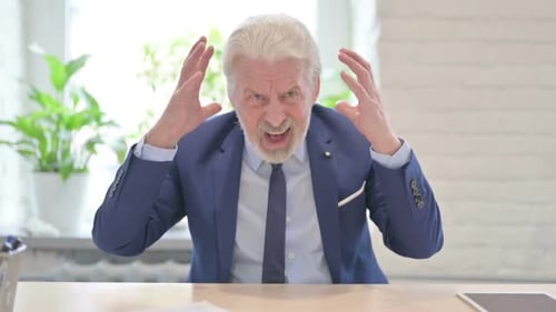 Senior Man Yelling at Desk in Workplace