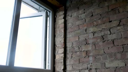 Open Window next to Red Brick Wall