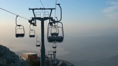 Silhouettes of cable cars over sea.