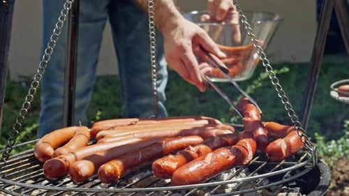 Enjoying the Process of Grilling Succulent Sausages on the Barbecue Outside in the Garden Slow Mo