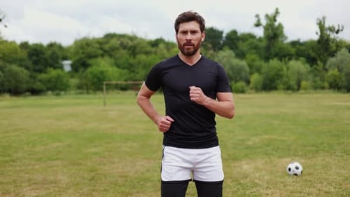 Selfassured Male Clad in Dark Complete Soccer Attire Running Around Stadium