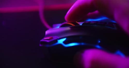 Close up shot of a hand scrolling the mouse wheel while playing games and clicking on a computer