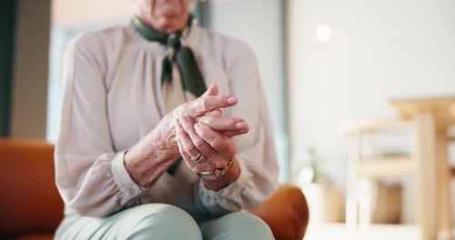 Senior Woman Rubbing Hands at Home