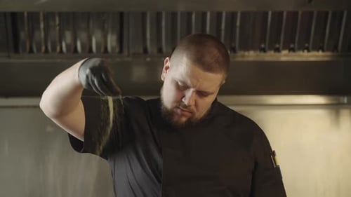 In Slow Motion As Ground Black Pepper Falls From the Chef's Hand Onto the Ribs