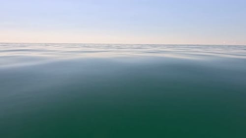 Meereswasseroberfläche, niedriger Winkel, Blick über klares azurblaues Meerwasser, Sonnenblendung, abstrakter nautischer Sommerozean
