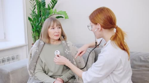 Doctor Examining Patient with Stethoscope in Home