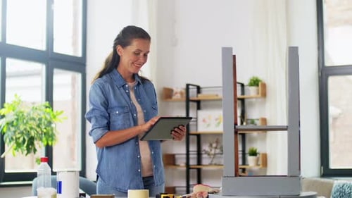 Woman Repairs Furniture Using Tablet for Instructions Indoors