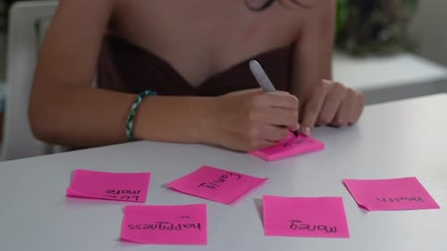 Femme écrivant ses résolutions du Nouvel An sur des notes autocollantes