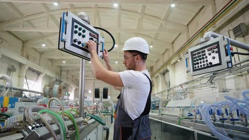 Worker On Factory Analyzes The Production Process And Programming Industrial CNC Machine Tool