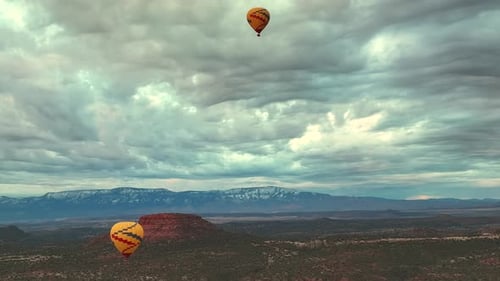 Hot Air Balloons Flying Against Cloudy Sunrise Sky Over Nature Landscape Of Sedona In Arizona, USA.