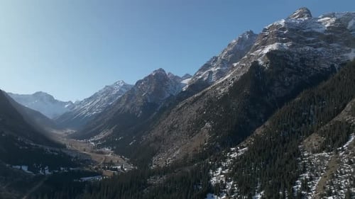 Vista aérea del valle montañoso del desfiladero de Barskoon con picos nevados, Kirguistán