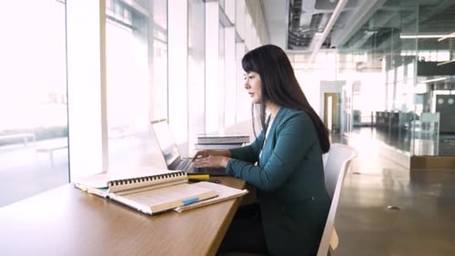 Mature Female College Student Studying at Laptop in Library Adult