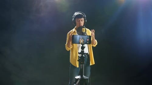 Young Adult Singing into Microphone with Recording Camera