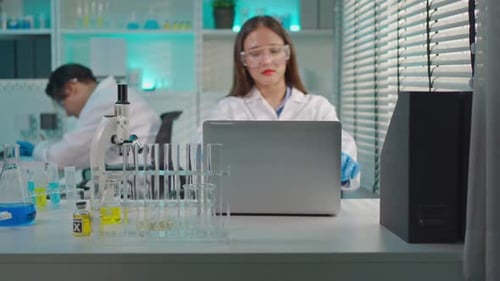 Woman Scientist Opens Laptop in Bright Laboratory